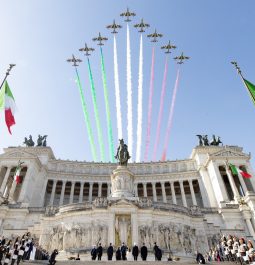 Planes are flying above the historic building leaving the three-colored trail