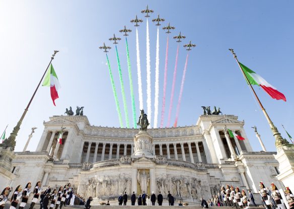 Planes are flying above the historic building leaving the three-colored trail