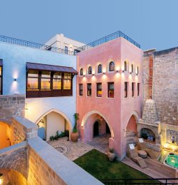 inner courtyard of stone hotel painted in pink and blue