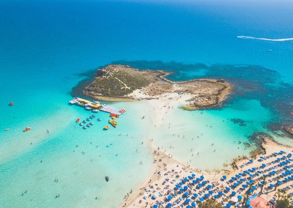 Aerial view of a beach with umbrellas and turquoise water